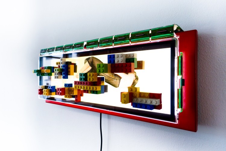 Art Alarm – Marck, Mutterglück, 2012, LCD Panel, Eisen, Lego, Video 32 Min 40 Sek, 16 x 42 x 11 cm